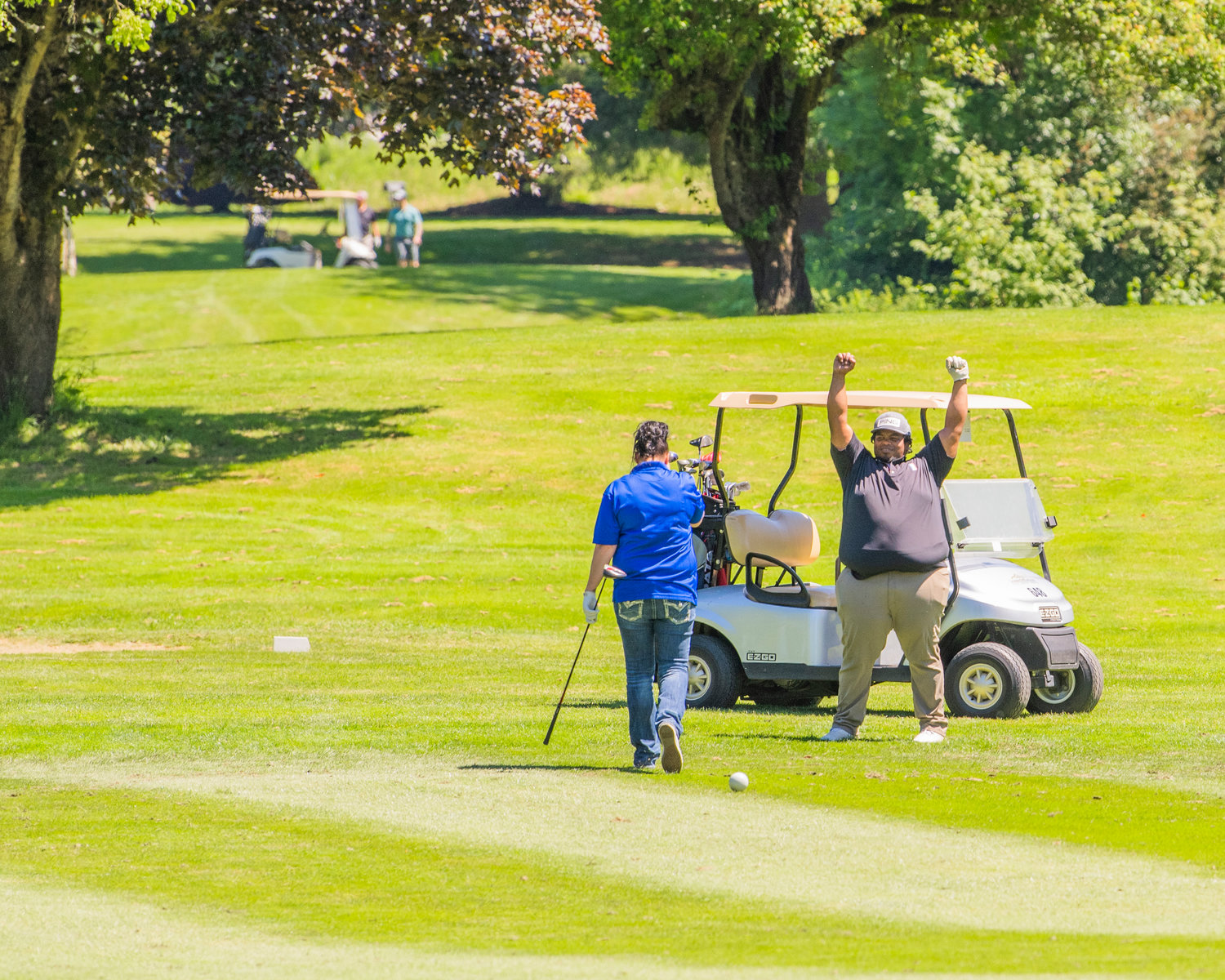 Chris Scieneaux cheers after Eddi Nelson tees off in the right directionFriday during a charity torunament at riverside Golf Course in Chehalis.